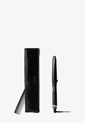 Pochette noire à motif crocodile avec zipper doré, peigne en plastique noir, et fer à friser noir avec un bouton gris et un cordon.