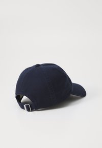 Navy blue cap with curved brim, cotton material, adjustable strap at the back, smooth texture, and stitched detailing on the crown.