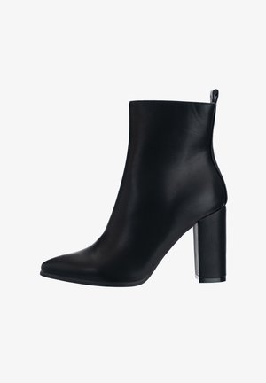 Bottine noire en matériau synthétique texturé, avec un bout pointu, un talon bloc haut et une languette à l'arrière pour faciliter l'enfilage.