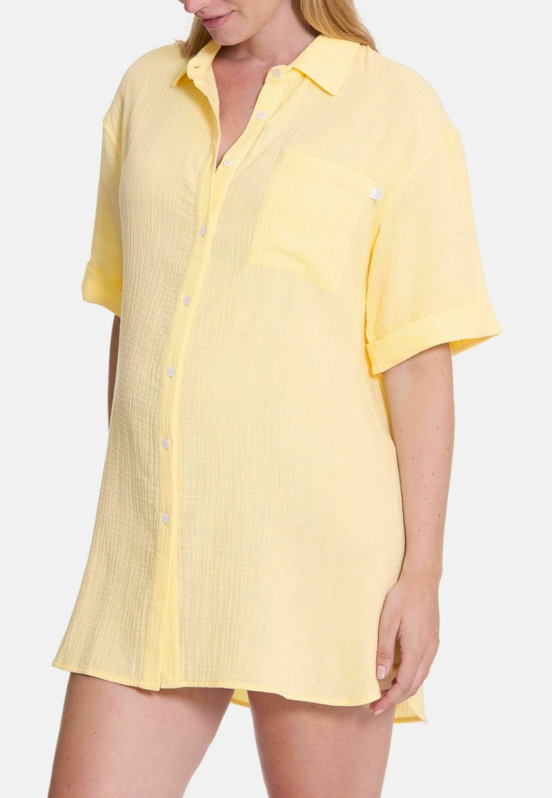 Korte mouwen, knoopsluiting shirt in lichtgeel, gemaakt van textuurstof met een borstzak en opgerolde mouwen. Zacht en ademend ontwerp.