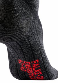 Calzino nero con un motivo testurizzato, aree rinforzate e lettering rosso. Progettato con una forma sagomata per comfort e supporto.