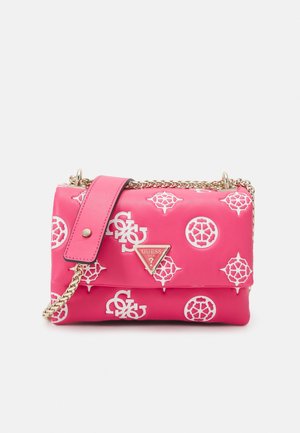 Pink Guess håndtaske med hvide monogrammønstre og en guldkæde som rem, med en pink læder skulderpude og en trekantet brandlogo-plade.