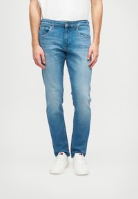 Világoskék, slim fit farmernadrág, �öt zsebbel és hagyományos gombos záródással. Az anyag enyhén kopott, ami laza megjelenést kölcsönöz.