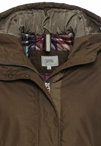 Braune isolierte Jacke mit einem hohen Kragen, glänzendem Innenfutter, Vorderreißverschluss und kariertem Futter in lila, rosa und blauen Farbtönen.