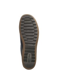 Semelle de chaussure en caoutchouc noir avec des rainures texturées, des bords marron contrastants et un logo. Design plat avec une finition lisse et une forme classique.