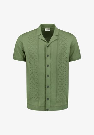 Chemise verte à manches courtes en tissu tricoté, ornée d'un motif géométrique texturé sur le devant, avec un col pointu et une fermeture à boutons.