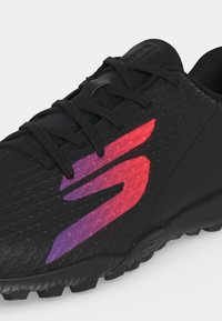 Chaussure de sport noire avec surface texturée, lacets noirs et grand logo dégradé du rouge au violet sur le côté.