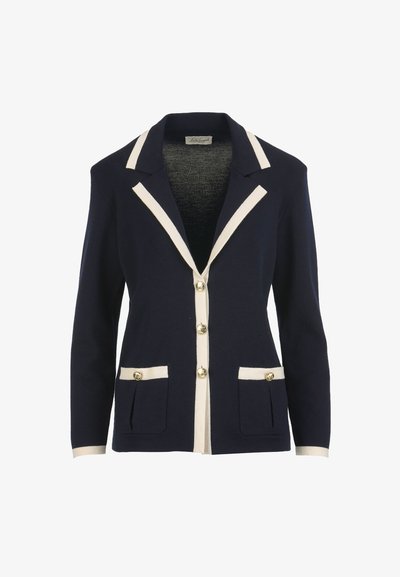 Navy blazer with cream trim on collar, lapels, cuffs, and pockets, featuring gold-tone buttons down the front and on pockets.