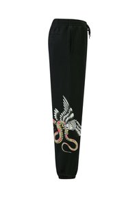 Svarta joggbyxor med elastisk midja, som har en stor grafisk design av en fågel och en orm i färg på underbenet.