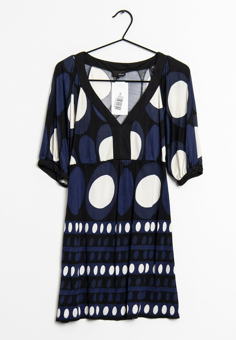 Robe noire avec de grands motifs ovales et circulaires blancs et bleu foncé, manches courtes, col en V, suspendue sur un cintre noir avec une étiquette de prix.