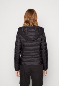 Černá péřová bunda s kapucí, se prošívaným vzorem a žebrovanými manžetami. Hladká textura a přiléhavý střih.