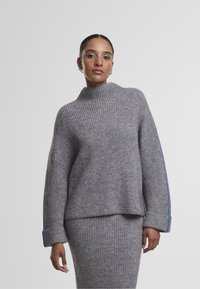 Grauer, gerippter Strickpullover mit hohem Kragen und breiten Bündchen, der an den Ärmeln blaue Akzentstreifen aufweist; weiche Textur und lockere Passform.