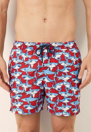 Shorts de bain rouges avec un motif répétitif de requins blancs et bleus. Fabriqués en tissu lisse et léger avec une taille à cordon de serrage ajustable.