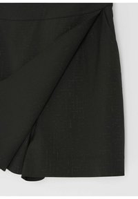 Czarna spódnica z tkaniny z nakładaj�ącym się przednim panelem i subtelnym wzorem teksturowym, wyeksponowana na jednolitym jasnym tle.