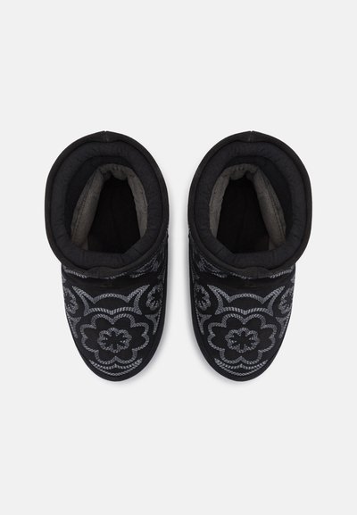 Black slippers with embroidered floral pattern in gray. Soft lining and padded cuffs for comfort. Rounded shape and closed toe design.