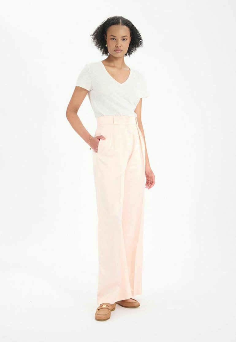 Pantalons taille haute rose clair avec des jambes larges et une taille ceinturée. Assortis à un haut blanc à col en V à manches courtes. Design simple, texture douce.