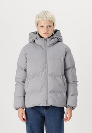 Jachetă puffer gri cu glugă, având fermoar frontal, manșete elastice și umplutură pufoasă. Purificată cu blugi albaștri. Design minimalist.