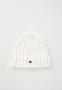Biała dziana czapka beanie o żebrowanej strukturze, z podwiniętym mankietem oraz małym akcentem logo w czerwonym, białym i niebieskim kolorze z przodu.