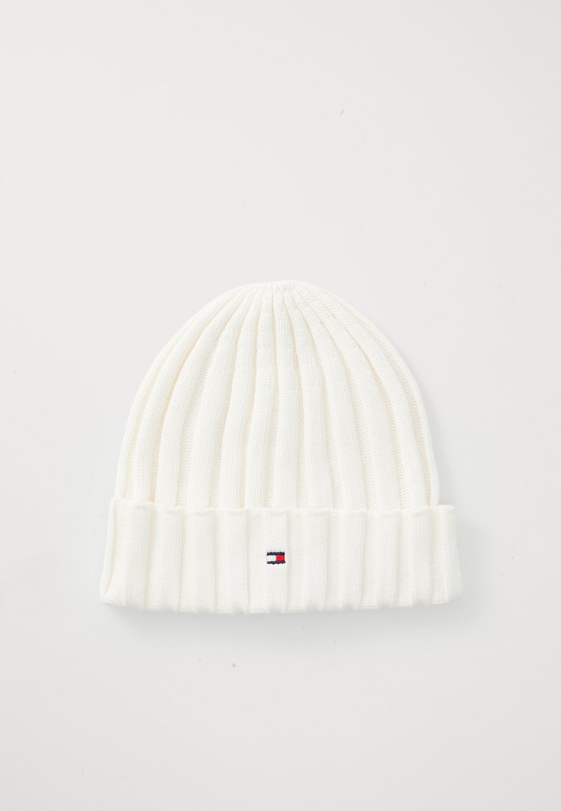 Biała dziana czapka beanie o żebrowanej strukturze, z podwiniętym mankietem oraz małym akcentem logo w czerwonym, białym i niebieskim kolorze z przodu.