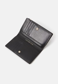 Black leather wallet with a smooth texture, featuring multiple card slots, a snap closure, and embossed brand logo in gold.