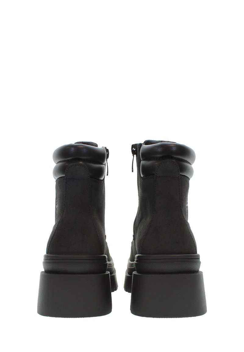Stivaletti neri con tomaia in suede, colletto arrotondato, chiusura con zip laterale e suola piatta nera e spessa.