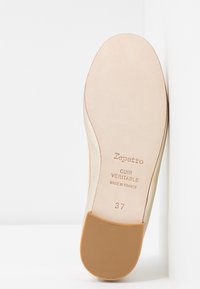 Suela de zapato de cuero en color nude, plana con un tacón de goma texturizada en tono marrón. El texto grabado incluye "Repetto", "Cuir Veritable" y la talla "37".