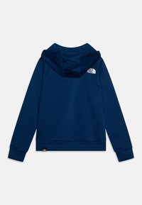 Temno modra kapuca iz mehke tkanine. Ima logotip na zgornjem hrbtu ter rebraste manšete in spodnji del. Sproščen dizajn z udobnim krojem.