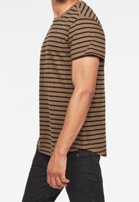 Camiseta de manga corta marrón con rayas negras horizontales. La tela parece suave; cuenta con un cuello redondo y un corte relajado.