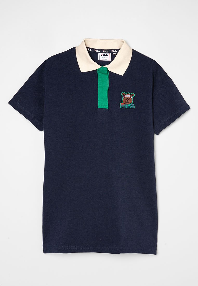 Marinblå polo t-shirt med krämfärgad krage och grönrandig knäppning. Har en broderad björnlogga på vänstra bröstet. Kortärmad.