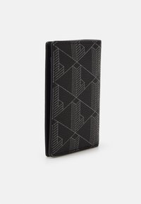 Portefeuille en cuir noir avec un motif géométrique gris, présentant une finition texturée et un design rectangulaire élégant.
