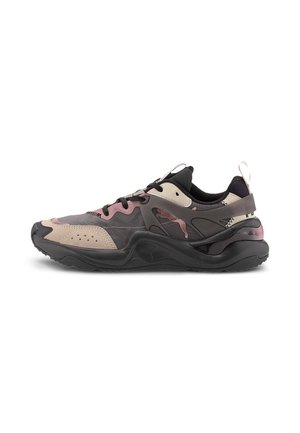 Moderner Sneaker mit schwarzen, beigen und pinken Einsätzen, dicker schwarzer Sohle, Schnürung vorne und Zuglasche an der Ferse, von der Seite gezeigt.