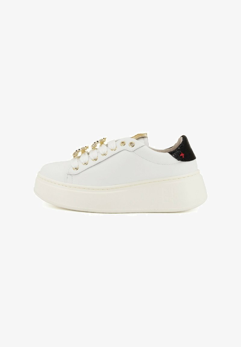 Sneaker platform bianco con occhielli dorati, accessori decorativi in oro e cristallo per i lacci, e linguetta nera sul tallone con dettagli di cucitura rossa.