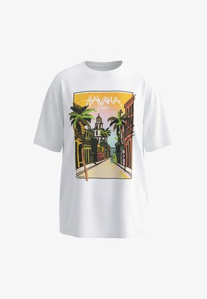 T-shirt blanc avec un graphisme coloré représentant une scène de rue à La Havane, avec des palmiers, des bâtiments et un clocher d'église au coucher du soleil.