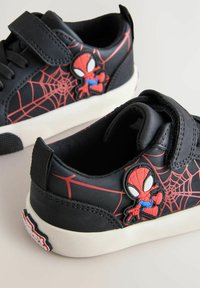 Musta lenkkarit, joissa on punainen hämähäkkiverkkokuosi, Spiderman-patch, tarranauha ja valkoinen kumipohja.