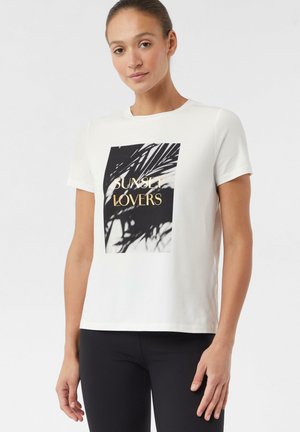 Weißes kurzärmliges T-Shirt mit einem schwarz-weißen Druck von Palmblättern und dem Text "SUNSET LOVERS" in goldener Schrift.