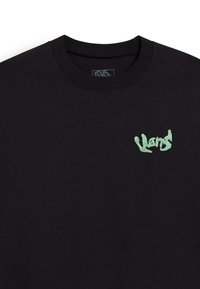 Camiseta negra de manga larga con un pequeño logo verde claro en el lado izquierdo del pecho. El tejido parece suave y tiene un escote redondo.