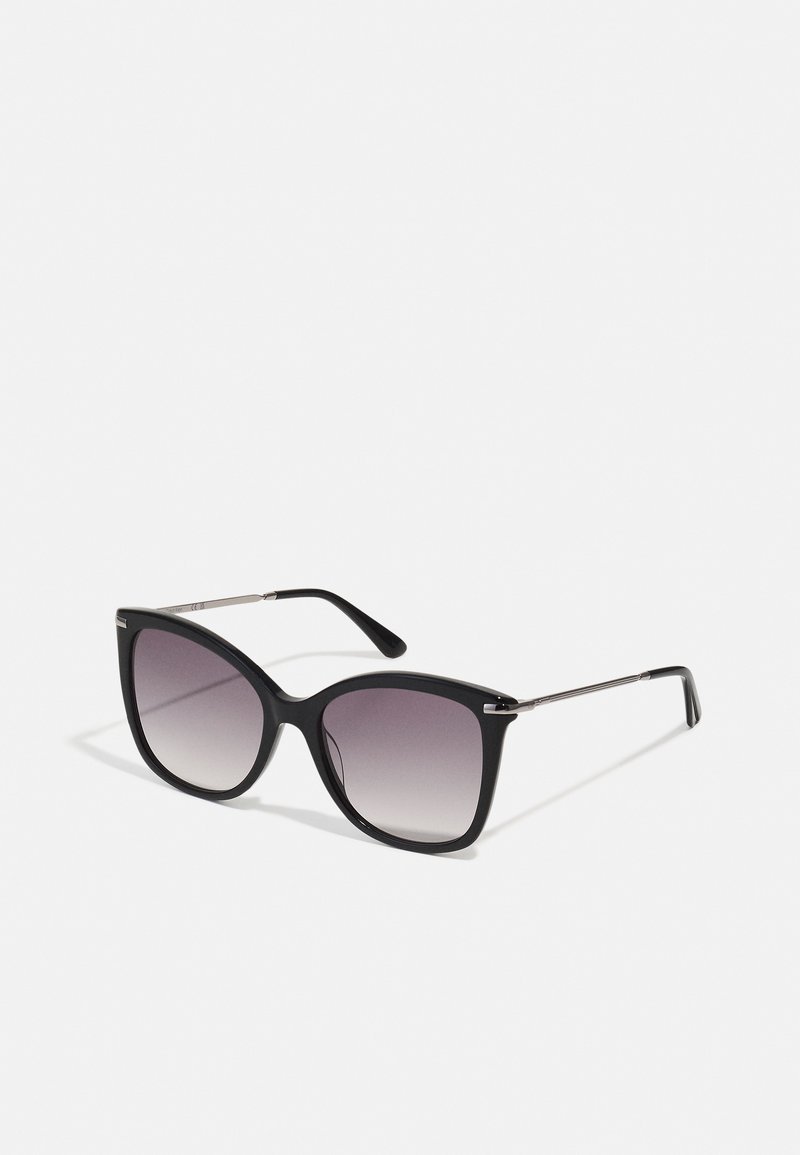 Ochelari de soare negri cu rame supradimensionate, pătrate. Tentă gri graduală în lentile. Accente subțiri din metal pe brațele ochelarilor îmbunătățesc designul elegant.