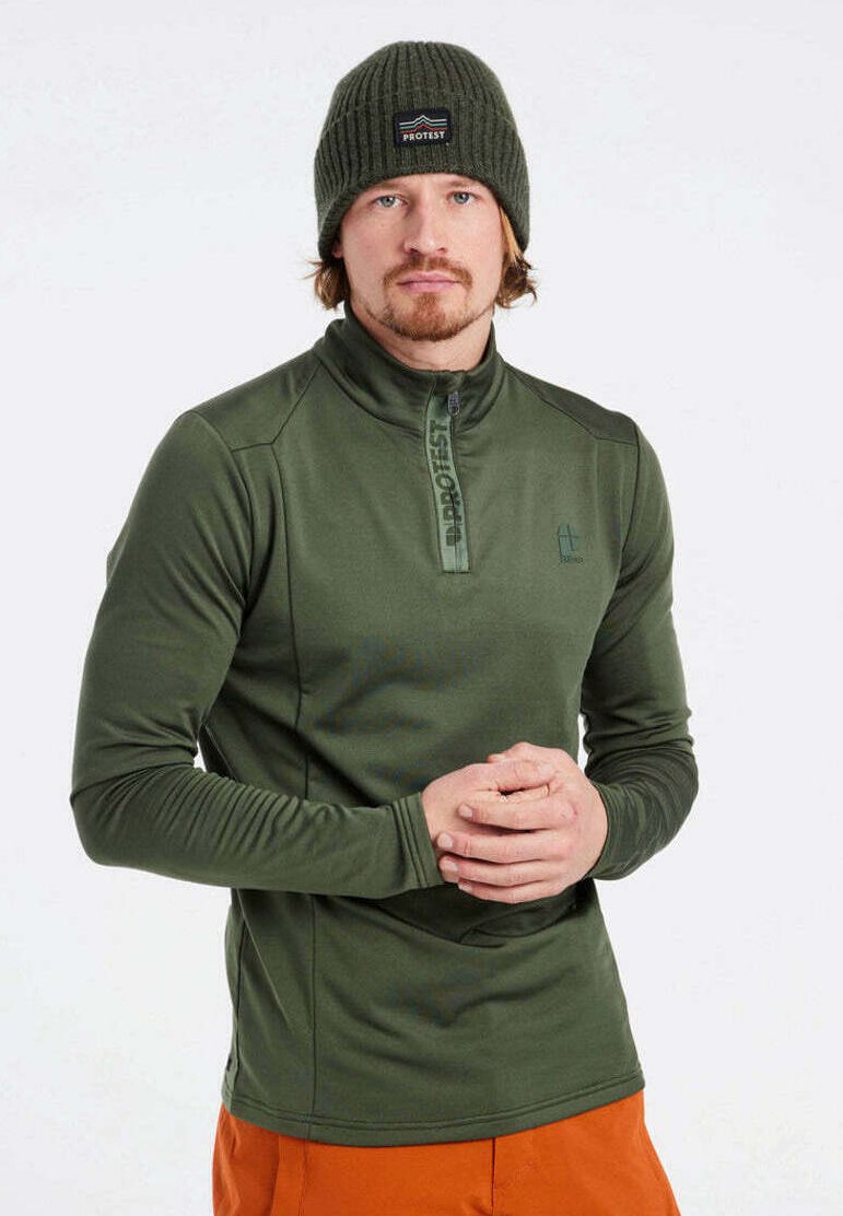 Grünes Langarm-Zip-Up-Oberteil mit hohem Kragen, versehen mit einem kleinen Logo und strukturierten Ärmeln, kombiniert mit einer olivfarbenen Strickmütze.