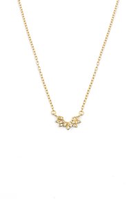 Collier en chaîne dorée avec un pendentif en forme de feuille orné de pierres précieuses transparentes, mettant en valeur des détails complexes et une finition brillante.