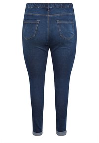 Mörkblå denimjeans med ett stretchigt midjeband, smalnande ben och två bakfickor. Omslag vid fållen ger detalj till designen.