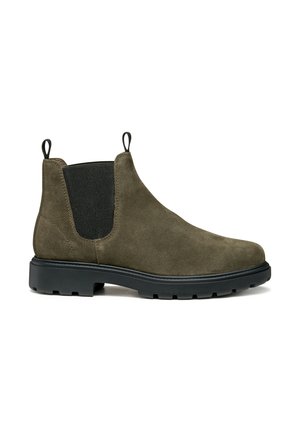 Botas Chelsea de ante verde oliva con paneles laterales elásticos, tiradores y una suela de goma negra robusta, con una textura suave y mate.