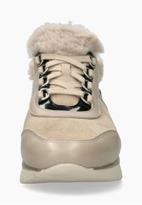 Chaussure de sport beige avec une tige en daim, un col en fausse fourrure douce, des accents noirs brillants et des œillets métalliques pour les lacets.