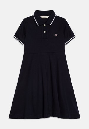 Robe polo marine en coton, avec un col, des manches courtes avec des accents blancs, une coupe évasée, et un petit logo sur la poitrine.