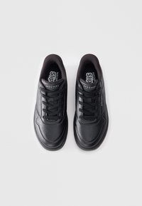 Black athletic shoes with a smooth leather upper, round toe, lace-up design, and perforated accents for breathability.