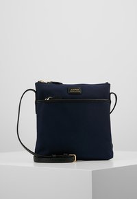 Borsa a tracolla in nylon blu navy con dettagli in pelle nera, hardware color oro, chiusura con zip e tasca frontale. Texture liscia, forma rettangolare.