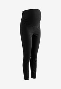 Zwarte zwangerschapslegging met een brede elasten band, zachte stof, slanke pasvorm en zijzakken. Ontworpen voor comfort en flexibiliteit.