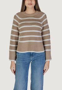 Maglione lavorato a maglia a righe marroni e bianche con scollo a costine, maniche larghe e orlo corto. Abbinato a jeans blu.