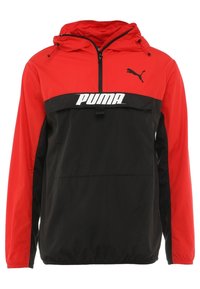 Rode en zwarte windjack met capuchon, voorzien van een ritssluiting aan de voorkant, elastische manchetten en een groot wit "PUMA"-logo op de borst.