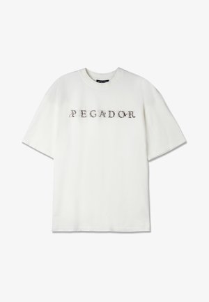 Hvit bomulls t-skjorte med rund hals og korte ermer, med "PEGADOR" trykt i dekorativ, mørk tekst over fronten.