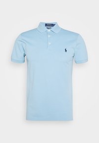 Polo bleu clair à manches courtes avec trois boutons et petit logo foncé sur la poitrine gauche, présenté sur fond blanc uni.